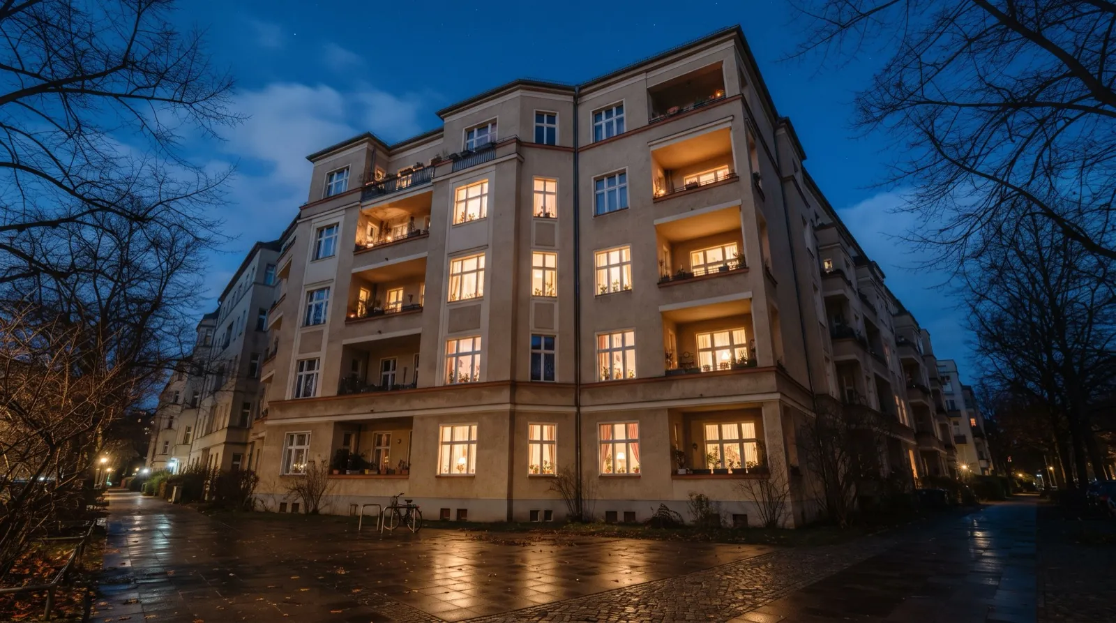 Wohnhaus mit beleuchteten Fenstern am frühen Abend